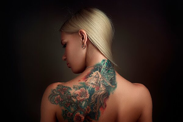Chica con tatuaje de color en la espalda