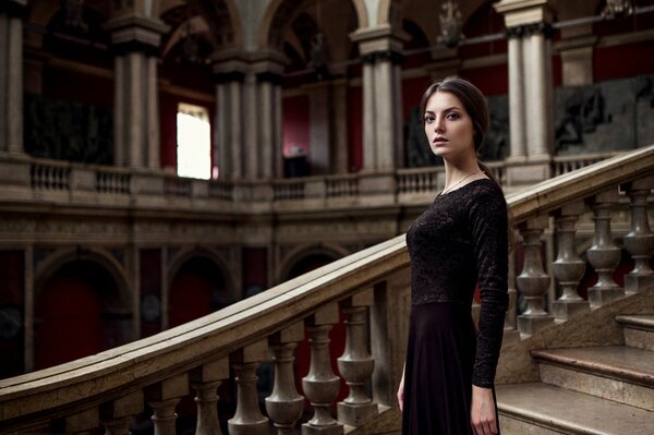 A girl on the steps of a huge castle