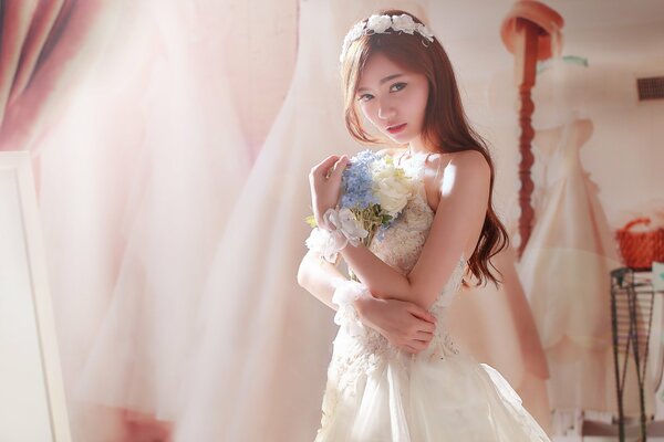 Chica en un vestido de novia con un ramo de flores