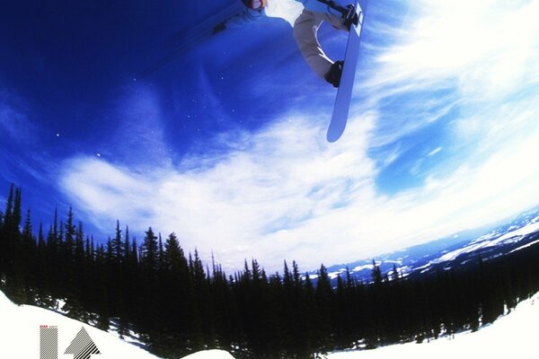 El truco de un atleta de snowboard en una montaña