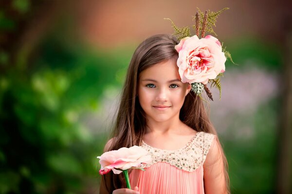 Belle fille avec une fleur rose dans les cheveux