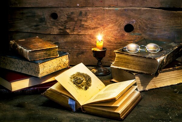 Books and glasses by candlelight