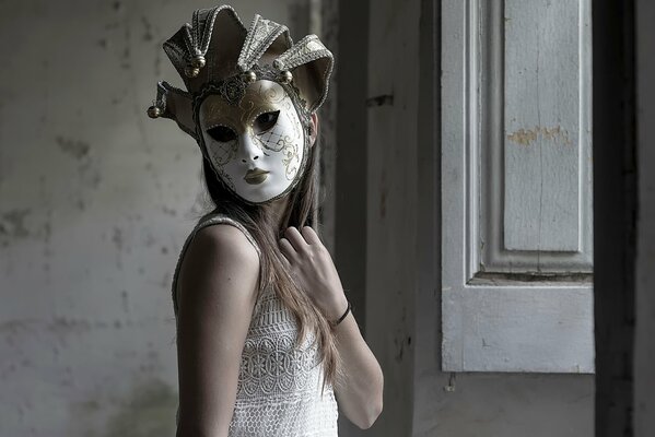 Mädchen in einer Stuckmaske neben einem Fenster