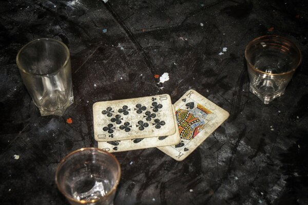 Three glass cups and playing cards