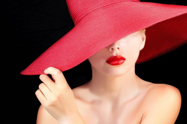 Belle fille au chapeau rouge rouge à lèvres sur les lèvres