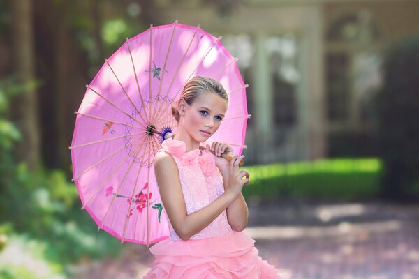 Fille dans une robe rose et avec un parapluie