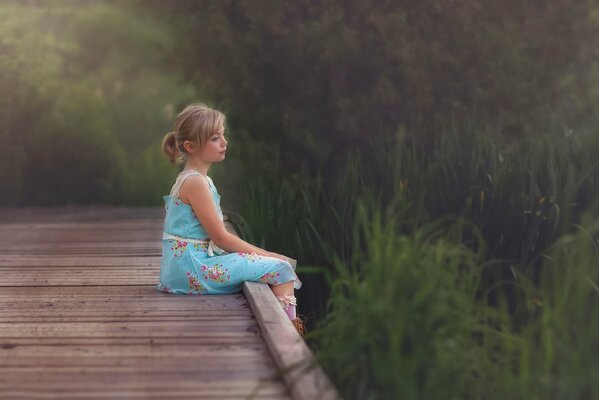 Lovely thoughtful girl on the bridge