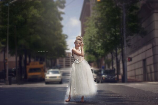 Mädchen im weißen Kleid auf der Straße der Stadt