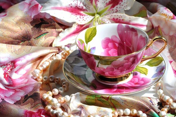 Photo of a cup with pink flowers and pearls