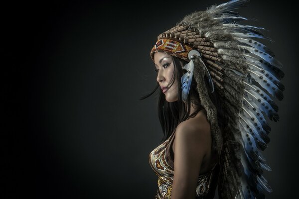 Chica en traje de indio apachrle, plumas elegantes