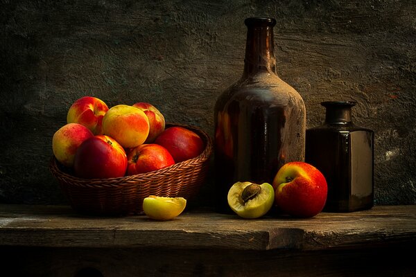 Panier de pêches et bouteilles sur la table