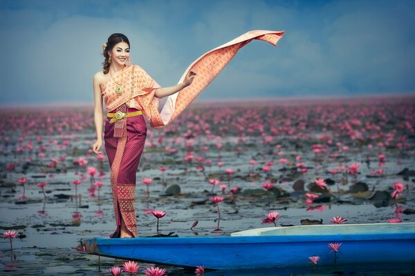 Oriental girl on a boat in flowers