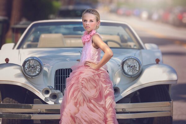 Ein Mädchen in einem rosa Kleid. Retro-Auto