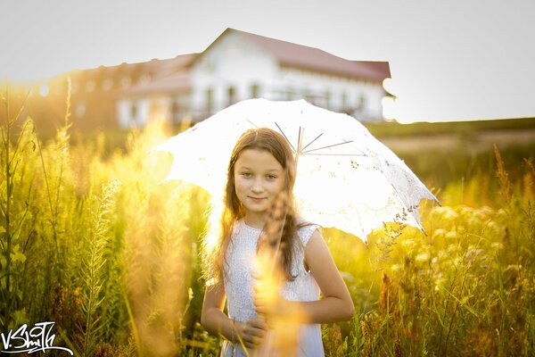 Fille dans un champ avec un parapluie