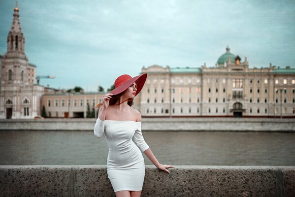 Ragazza in abito bianco. ragazza con cappello rosso. fiume. lungomare