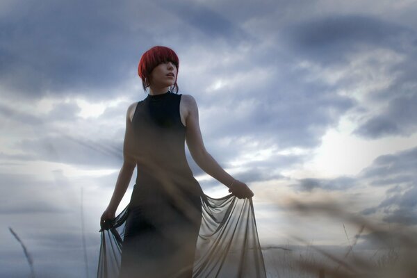 A girl with red hair against the background of nature