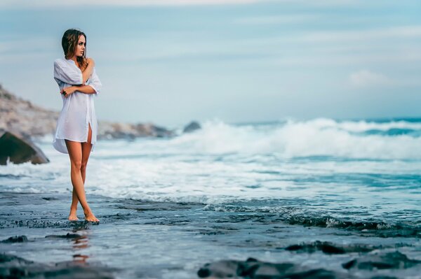 Fille en chemise au bord de la mer