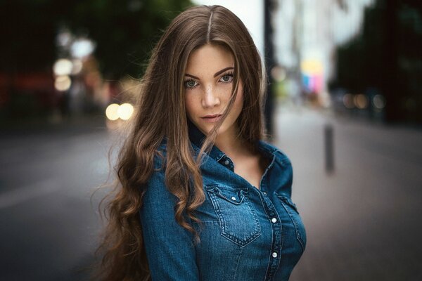 Ragazza in un vestito di jeans sullo sfondo della città