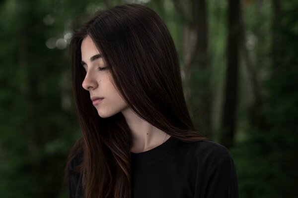 Dark-haired girl on the background of the forest