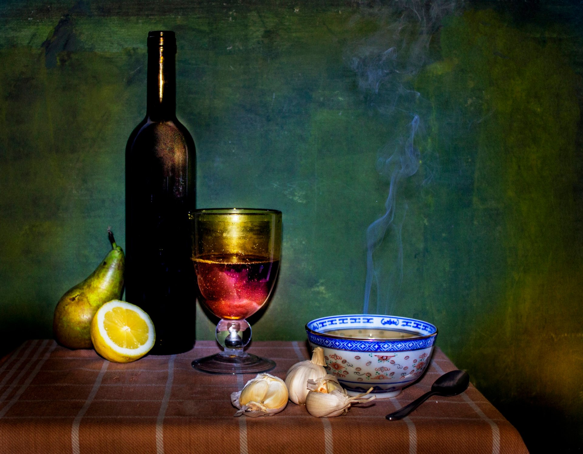 a bowl of soup a bottle dish table still life