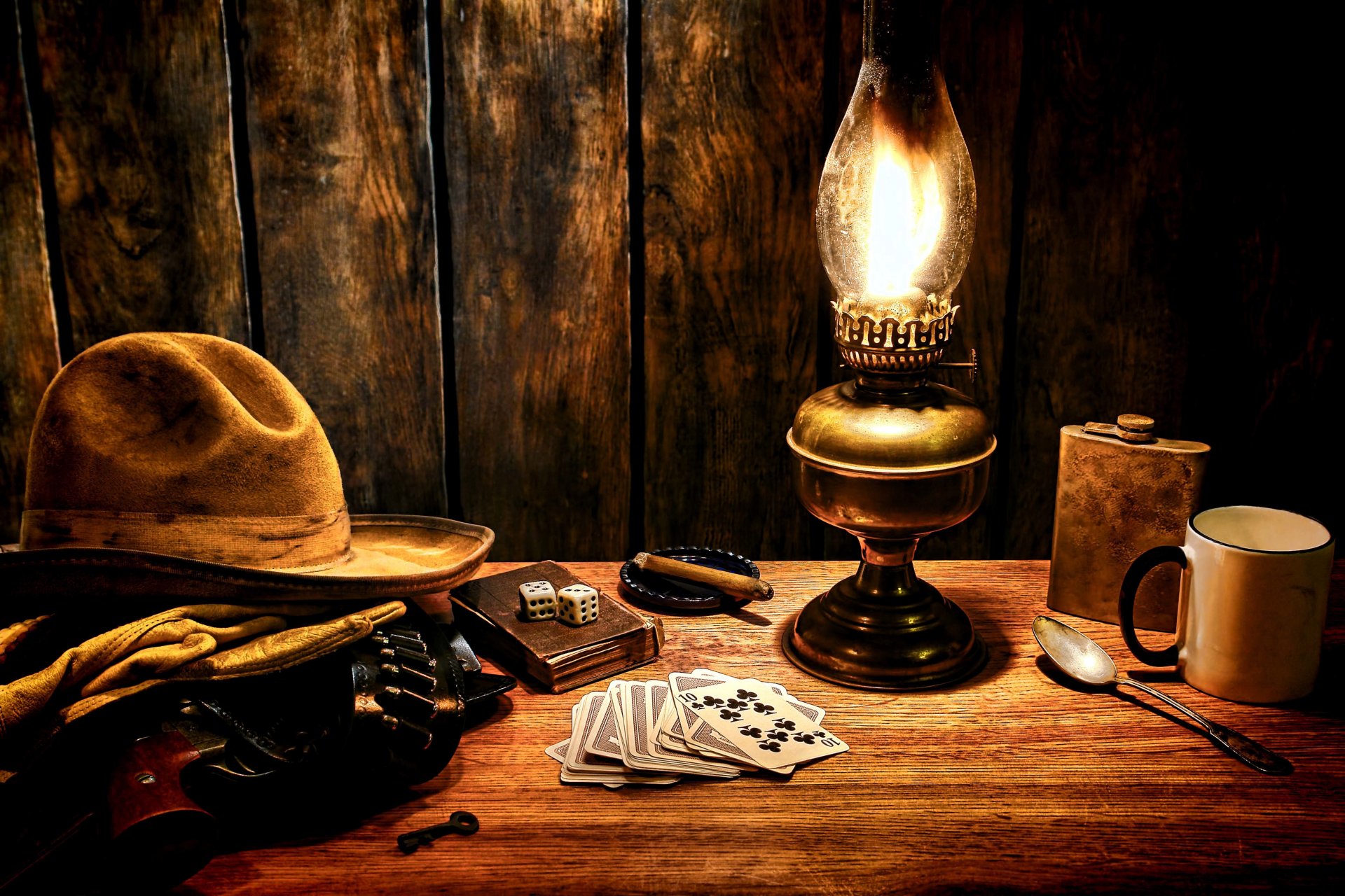 tavolo superficie cowboy cappello guanti revolver colt bandoliere selvaggio west lampada carte da gioco dadi dadi tazza fiaschetta chiave sigaro stile occidentale occidentale carta da parati