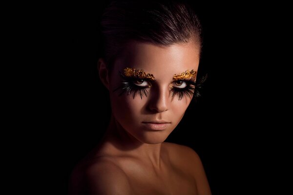 Portrait de jeune fille avec maquillage sur fond noir