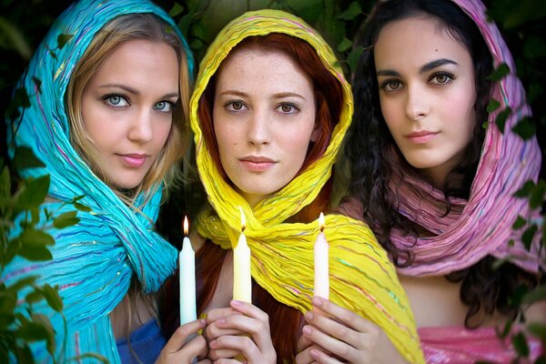 Tres chicas con velas encendidas en sus manos