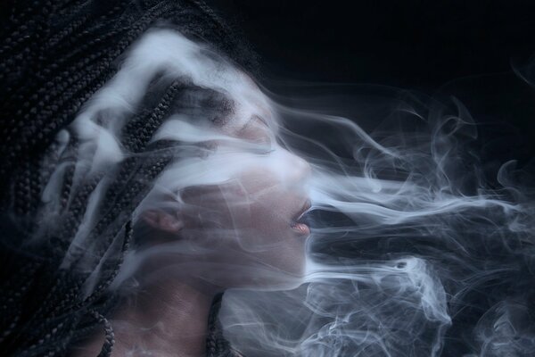 Una chica con afrocos. Cabeza en el humo