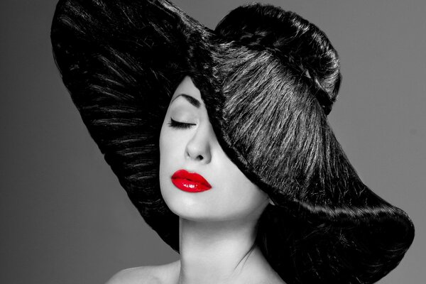 Mujer elegante con sombrero negro y lápiz labial rojo