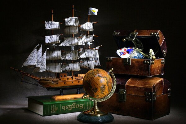 Photos of models of a sailboat, a chest and a globe