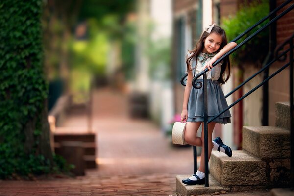 Fotografía de bebé niña en los escalones en un dulce día