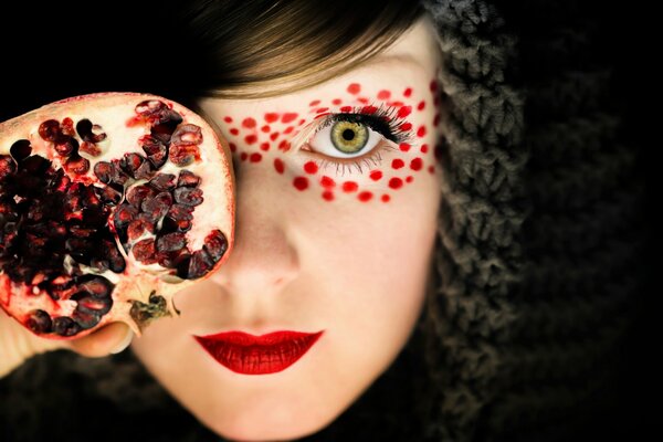 Make-up Mädchen mit Granatapfel in der Hand
