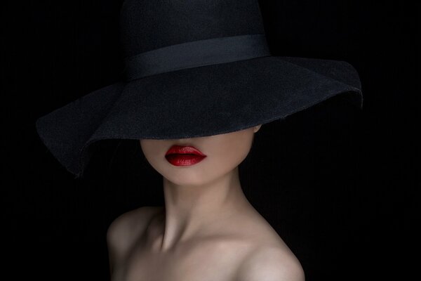 Portrait of a girl in a black hat with red lips