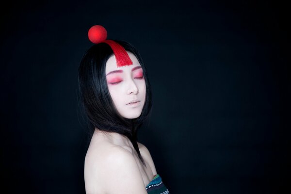 Foto eines Mädchens mit einer roten Kugel auf dem Kopf