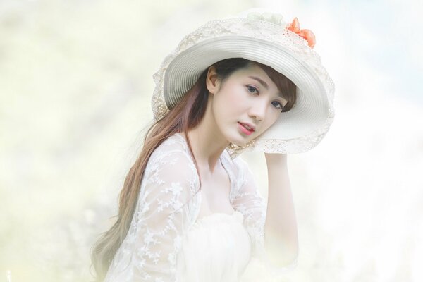 A girl on a light background with a hat