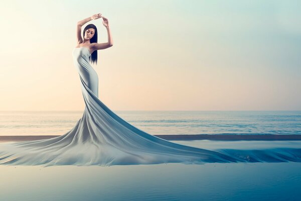 A girl in a flowing dress on the background of the sea