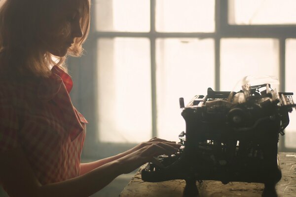 Ruda dziewczyna za maszyną do pisania retro
