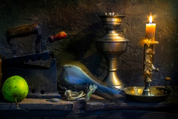 Still life with antique coins, candle, apple and iron