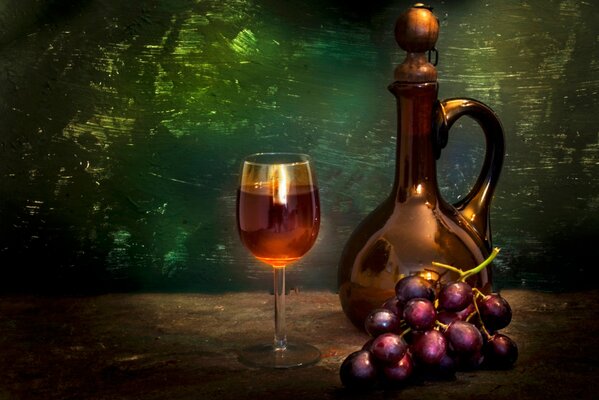 Натюрморт, на котором изображен кувшин и рядом стоит бокал вина, рядом кисть красного винограда