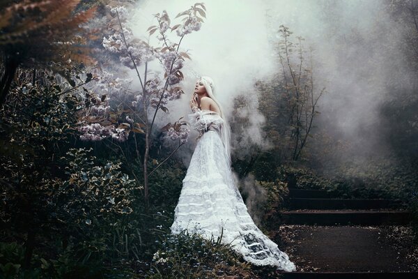 A girl in a white dress in a gloomy forest