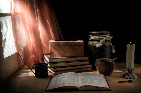 Martwa natura książki, świeca i zasłony