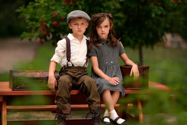 A girl and a boy are sitting on a bench