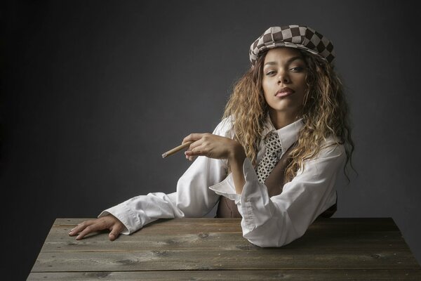 Photo of a stylish girl in a cap at the table