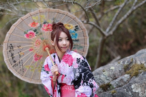 Asian girl, in a stylish outfit with an umbrella