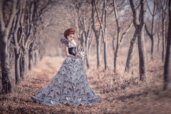 Fille en robe de journaux dans le jardin