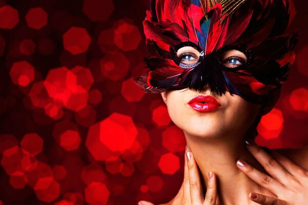 Masquerade. A girl in a feather mask on a red background