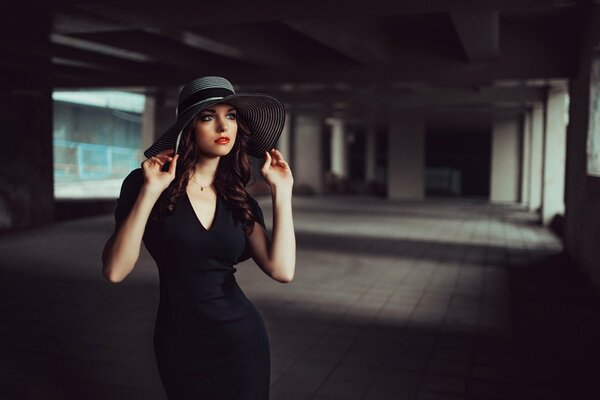 Ragazza in un cappello e in un vestito nero