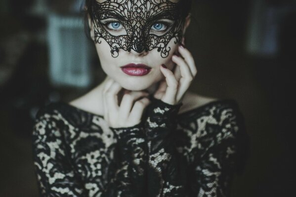 Masque de mascarade et robe noire sur la fille