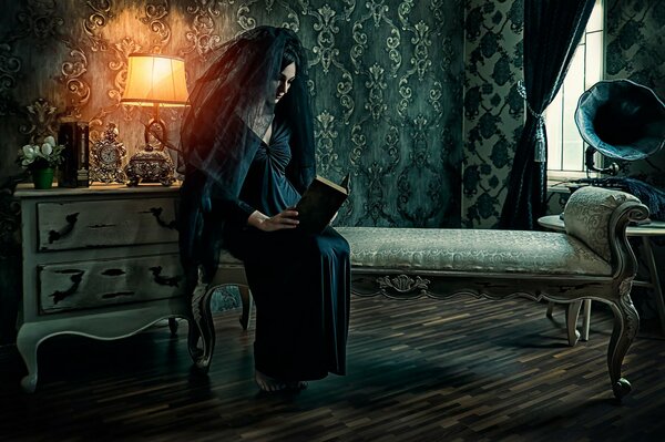 Mujer con velo negro y vestido negro leyendo un libro en una habitación oscura