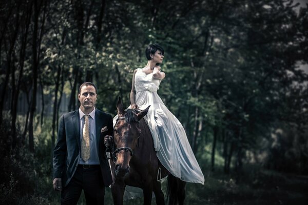 Un hombre en traje conduce un caballo con una chica a caballo, una pareja elegante